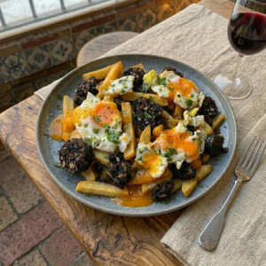 Huevos fritos con morcilla sobre patatas